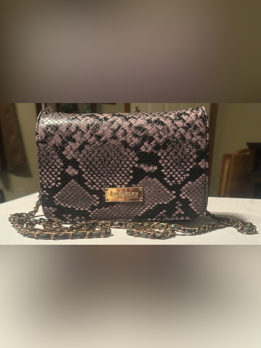 Bebe Los Angeles Snake-Embossed Purple Crossbody Bag with Chain.